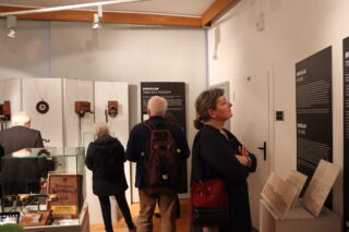 Zwiedzający oglądają ekspozycję w dalszej części sali wystawowej.