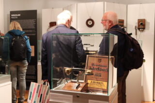 Zwiedzający oglądają ekspozycję dawnych aparatów i wyposażenia telekomunikacyjnego.
