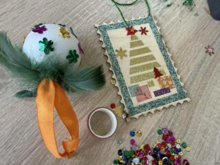 Ozdoby choinkowe - bombka i drewniany znaczek pocztowy.